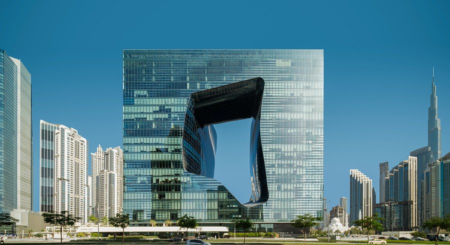 A mirrored glass cube with a rounded void cut through its centre, designed by Zaha Hadid.