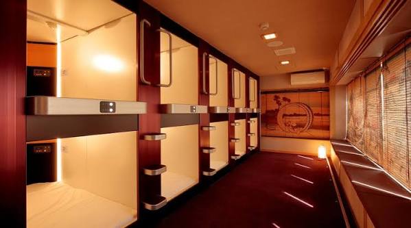 A row of wooden-framed sleeping capsules with blinds, in a women-only capsule hotel in Tokyo.